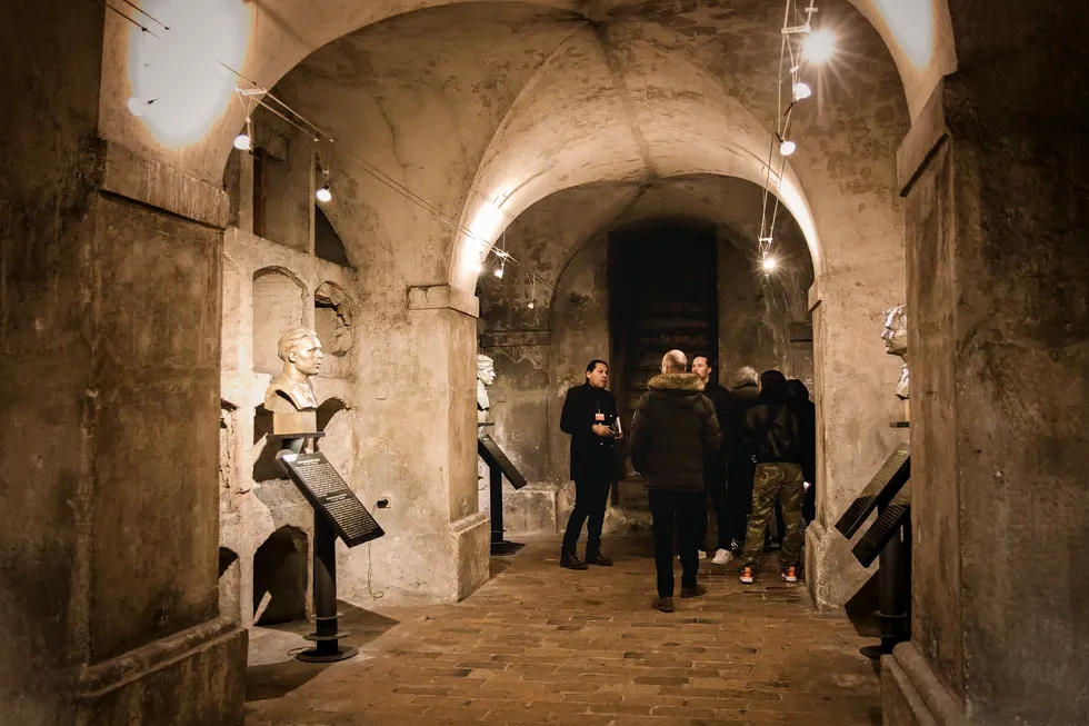tourists in hallway of National Monument to the Heroes of the Heydrich Terror